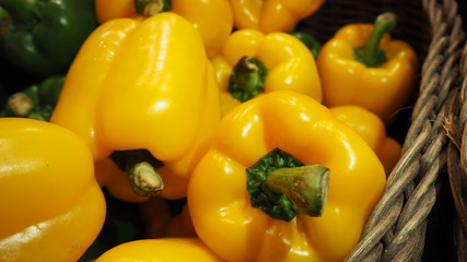 Bell pepper or paprika in green and yellow in basket at market