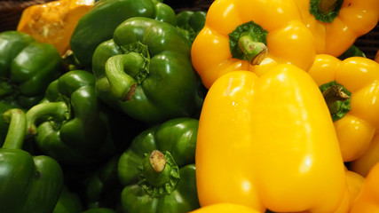  Bell pepper or paprika in green and yellow in basket at market.	 