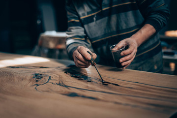 Obraz premium treatment of wood with varnish, epoxy, paint. manual manufacturing of furniture from solid .