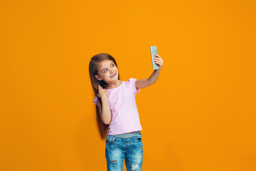 The happy teen girl standing and smiling with phone