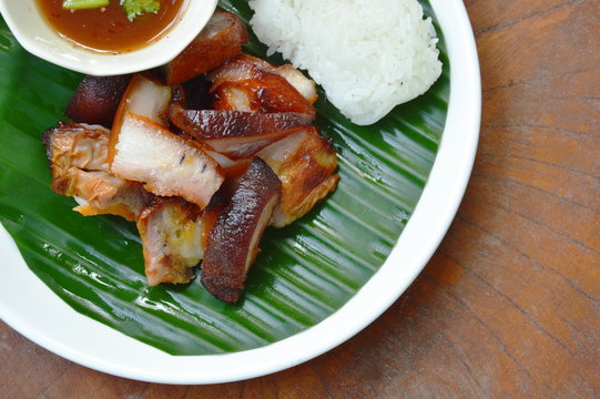 barbecue pork belly with sticky rice and dipping spicy sauce on plate