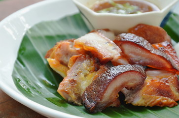 roasted pork belly with sticky rice and dipping spicy sauce on plate