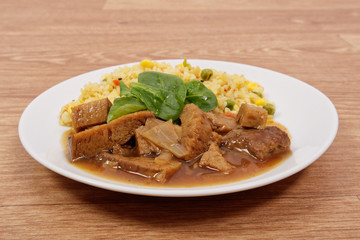 Tempeh with tomato sauce and millets on a table