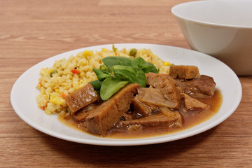 Tempeh with tomato sauce and millets on a table