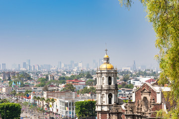 Fototapeta na wymiar Shrine of Our Lady of Guadalupe, view of the old basilica from the eighteenth century. In the distance, the panorama of Mexico City