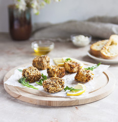 Cheese, diced and fried in batter and sesame on a wooden Board. White background.