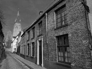 Beautiful monochrome image of a traditional narrow stone paved street in Bruges, Belgium