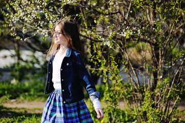 Kid girl in blooming apple garden