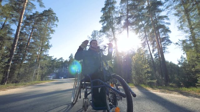 Disabled man uses special equipment to move on a road, close up.