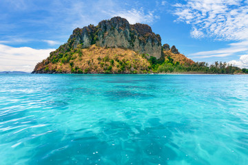 Naklejka na ściany i meble Spectacular scenery the tropical island with the limestone cliffs covered with the vegetation in the crystal clear ocean next to the exotic Phi Phi Islands, the Kingdom of Thailand. Paradise image.