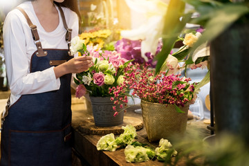 young women business owner florist making bouquet  in front of flower shop. - obrazy, fototapety, plakaty