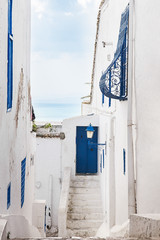 Fototapeta na wymiar blue door and windows in white Arab courtyard Tunisia
