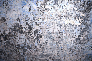 background of a wall with many layers of faded, ragged paint of different colors