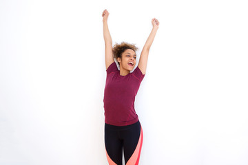 cheerful young african american woman with arms raised against white background