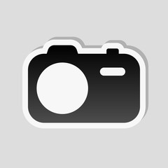 Simple photo camera. Technology icon. Sticker style with white b