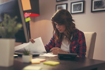 Woman reviewing documents in home office