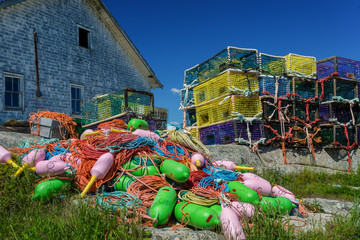 Lobster traps and buoys piled up in the seaside village of Peggy's Cove, Nova Scotia, Canada.