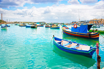 Fototapeta na wymiar Luzzu boats in Marsaxlokk Port in bay Mediterranean sea Malta