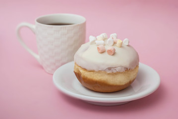 Obraz na płótnie Canvas Close up Doughnuts with White Icing on White Plate and A Cup of Coffee over Pastel Pink Background. Sweet Dessert Donuts with Copy Paste.