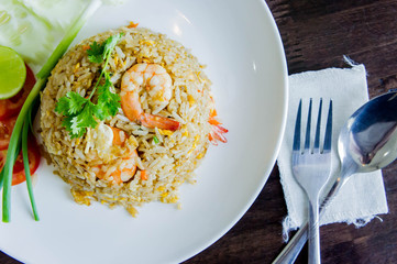 Fried rice with shrimp in a white dish on wood table in thai food style