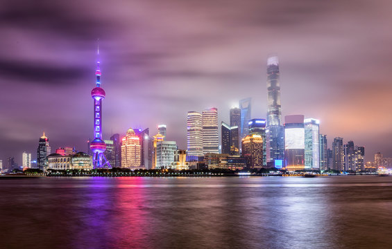 Die bunt beleuchtete Skyline von Shanghai, China, an einem bewölktem Abend