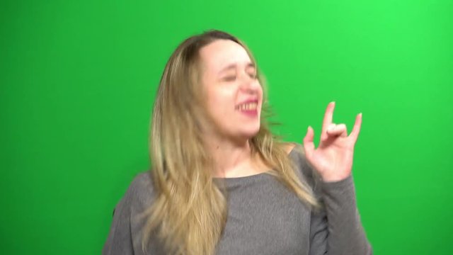 Young girl posing. Good mood. Performs arbitrary rhythmic movements. Background green screen.
