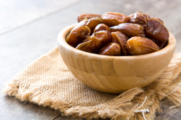 dates food in wooden bowl on wooden table