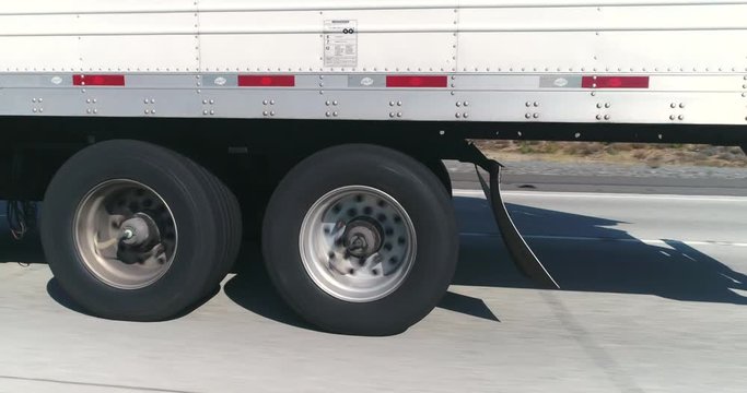 pov shot of semi trailer truck traffic on highway. Truck and camera by side - August 2017: Interstate 15, California, US