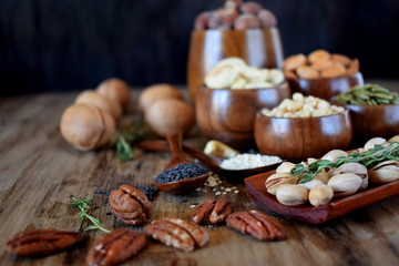 Fototapeta premium Different nuts and seeds in wooden spoons and bowls