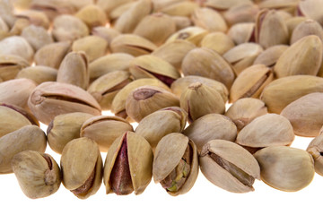 a lot of pistachios salted and fried on a white background