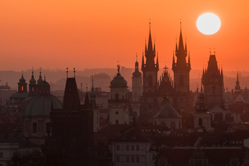 Fototapeta na wymiar Twilight in historical city. Magical picture of tower with orange sun in Prague,