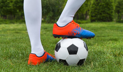 Football player and ball on a grass close-up