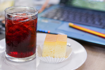 Red water and butter cream on white dish, blurred the blue tablet background.