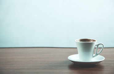 White coffee cup on wood background.