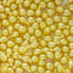 Background - close up of countless yellow colourful medicine  pills with shallow depth of field, bokeh