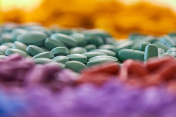 Obraz premium Background - close up of countless colourful medicine pills with shallow depth of field, bokeh