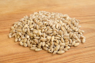 heap of barley pearl in wooden background.