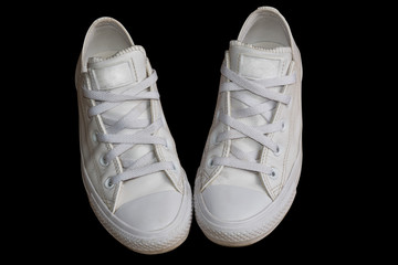 Closeup white trendy female leather sneakers isolated on the black background