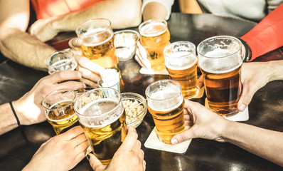 Vriendenhanden die bier drinken in brouwerijcaférestaurant - Vriendschapsconcept met jonge mensen die samen genieten van tijd en echt plezier hebben in een coole vintage brouwbar - Focus op midden rechts klein glas
