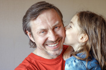 The daughter kissing father gently in cheek