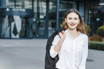 Fototapeta premium A business woman goes down the street. A girl in a business suit at the office. A wonderful girl in the city.