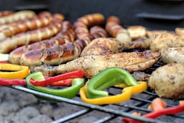  Tasty food, nutrition, culinary and barbecue concept: grilled sausages,chicken thigh and vegetables on a barbeque.