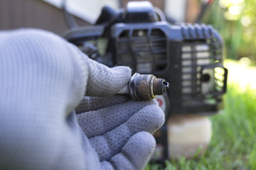 Replacement of the spark plug in the internal combustion engine of the lawn mower.