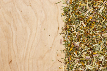 Dried herb leaves on wooden board with copy space