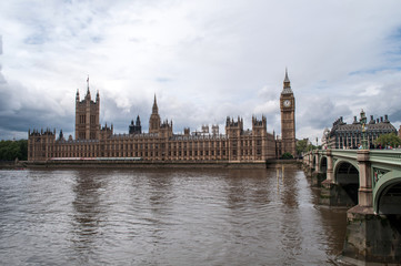 Obraz na płótnie Canvas The British Parliament, and the Big Bens clock at the Thames River in Westminster - London, United Kingdom