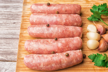 Sausages for grilling on a wooden cutting board