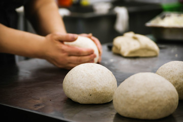 Fototapeta na wymiar Women's hands knead the dough