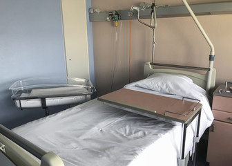 Empty hospital bed and newborn baby near the bed