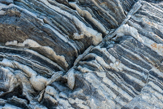 Compressed rock layers formation in various colors and thicknesses, on south central coast of the  Mediterranean island Crete, Greece. Nature and Geological science concept