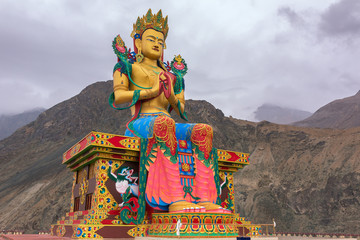 Maitreya Buddha statue with Himalaya mountains in the back at Diskit Monastery, Nubra Valley, Ladakh, India.